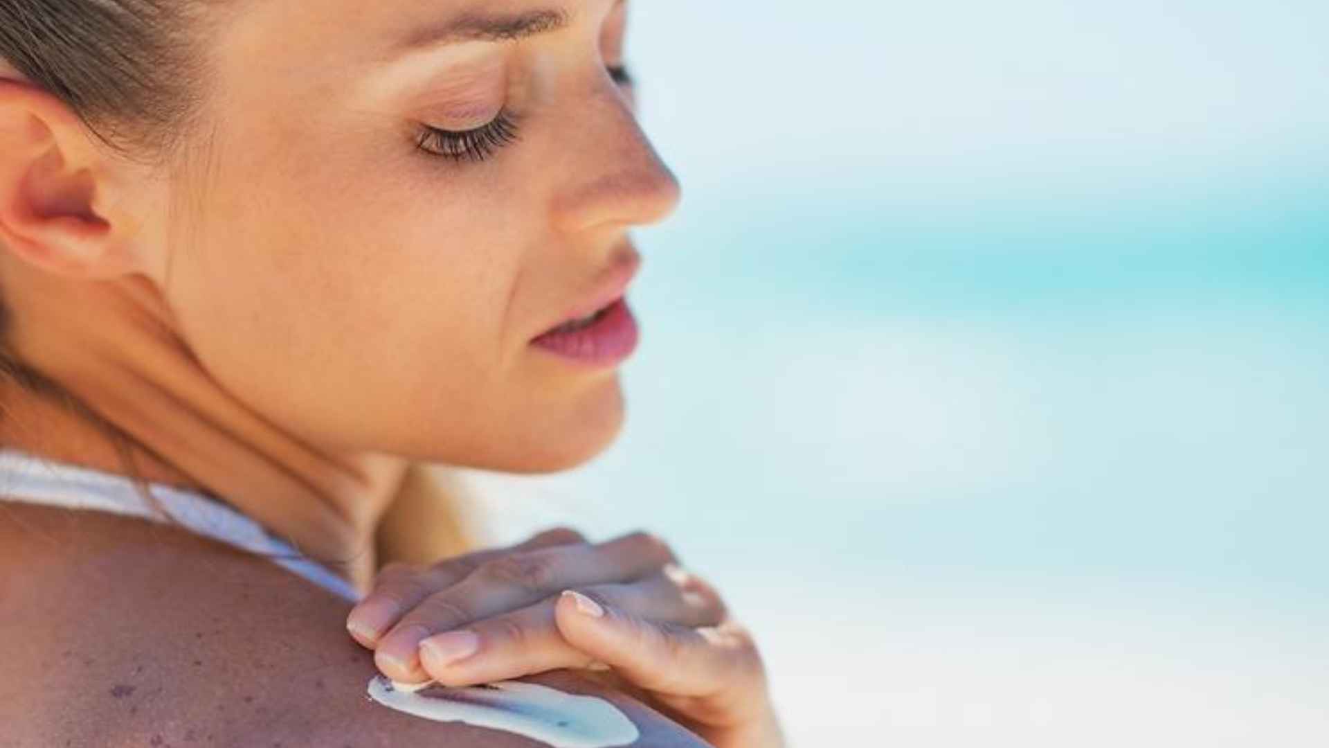 A woman applying sun lotion