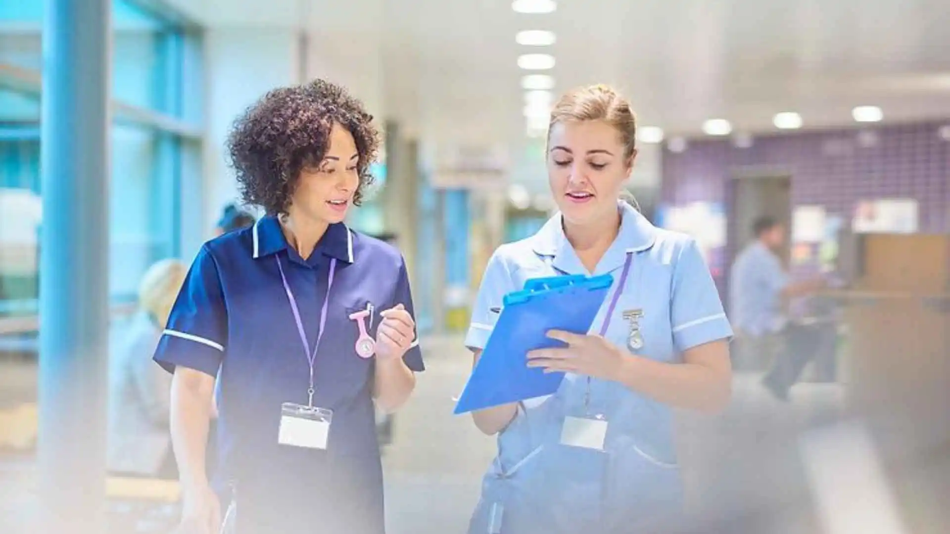 Two female health professionals talking while walking
