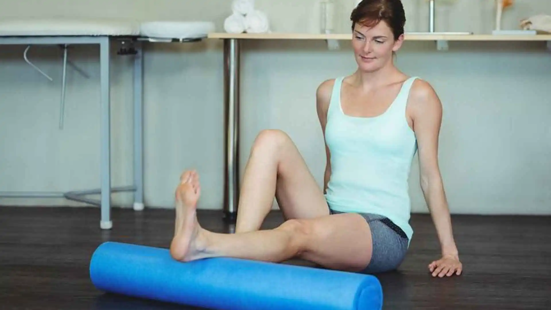 A woman using a foam roller inside her home