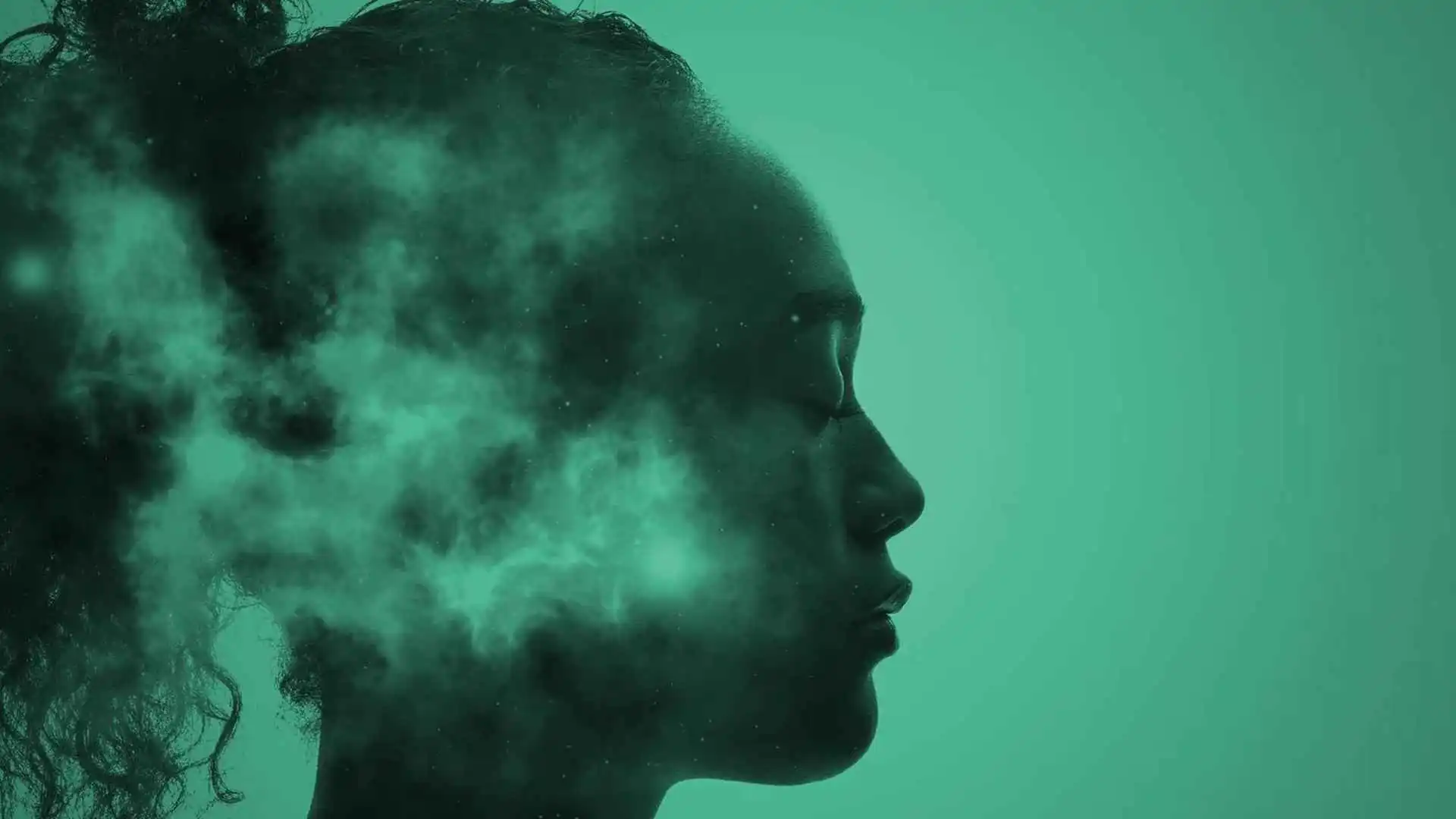 A woman with her eyes closed with smoke or mist in front of her face in an abstract pose