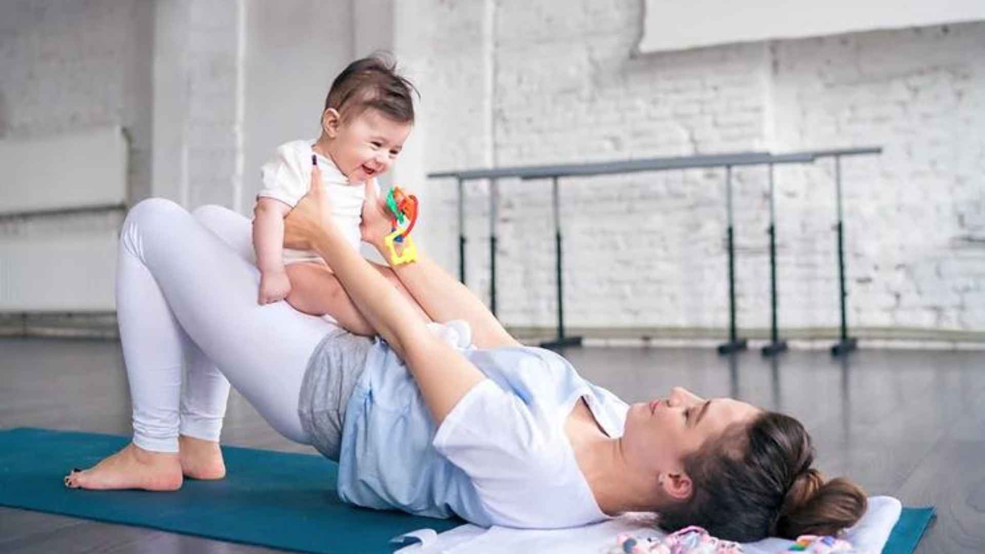 A woman doing exercises using a baby as a weight