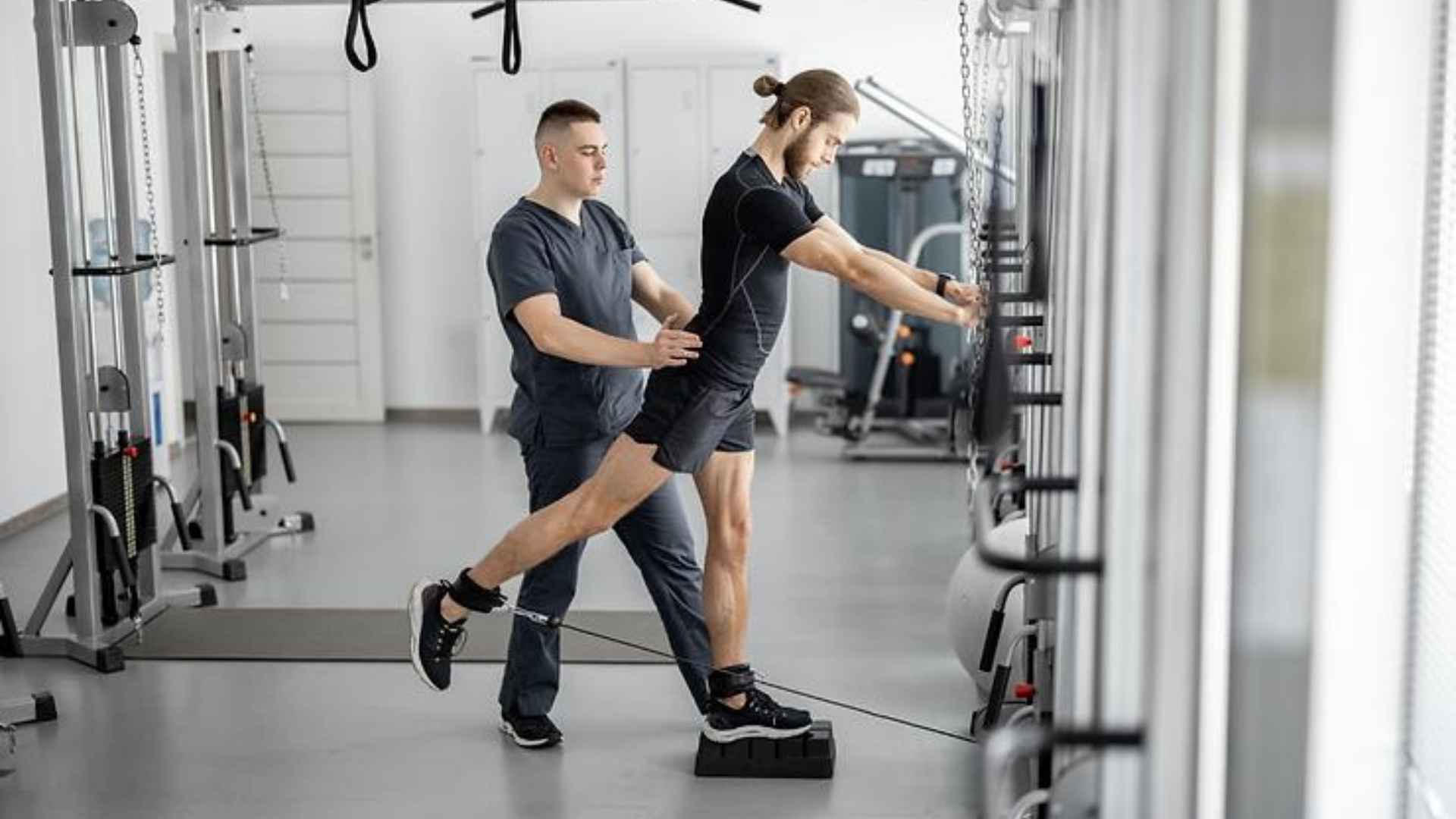 A man and his trainer doing weighted leg excercises