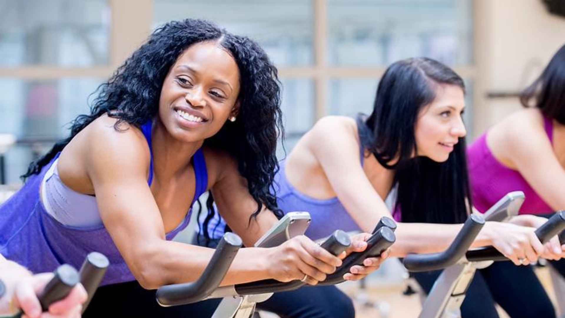 Women on exercise bikes in a gym