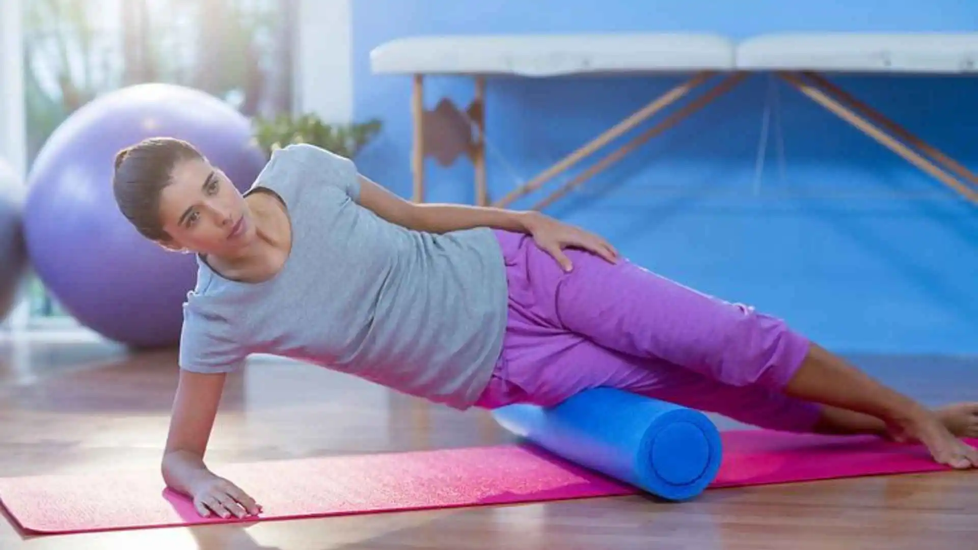A lady using a foam roller on her legs